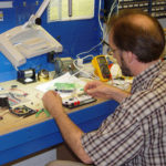 Designer using a breadboard for testing part of a product invention prototype